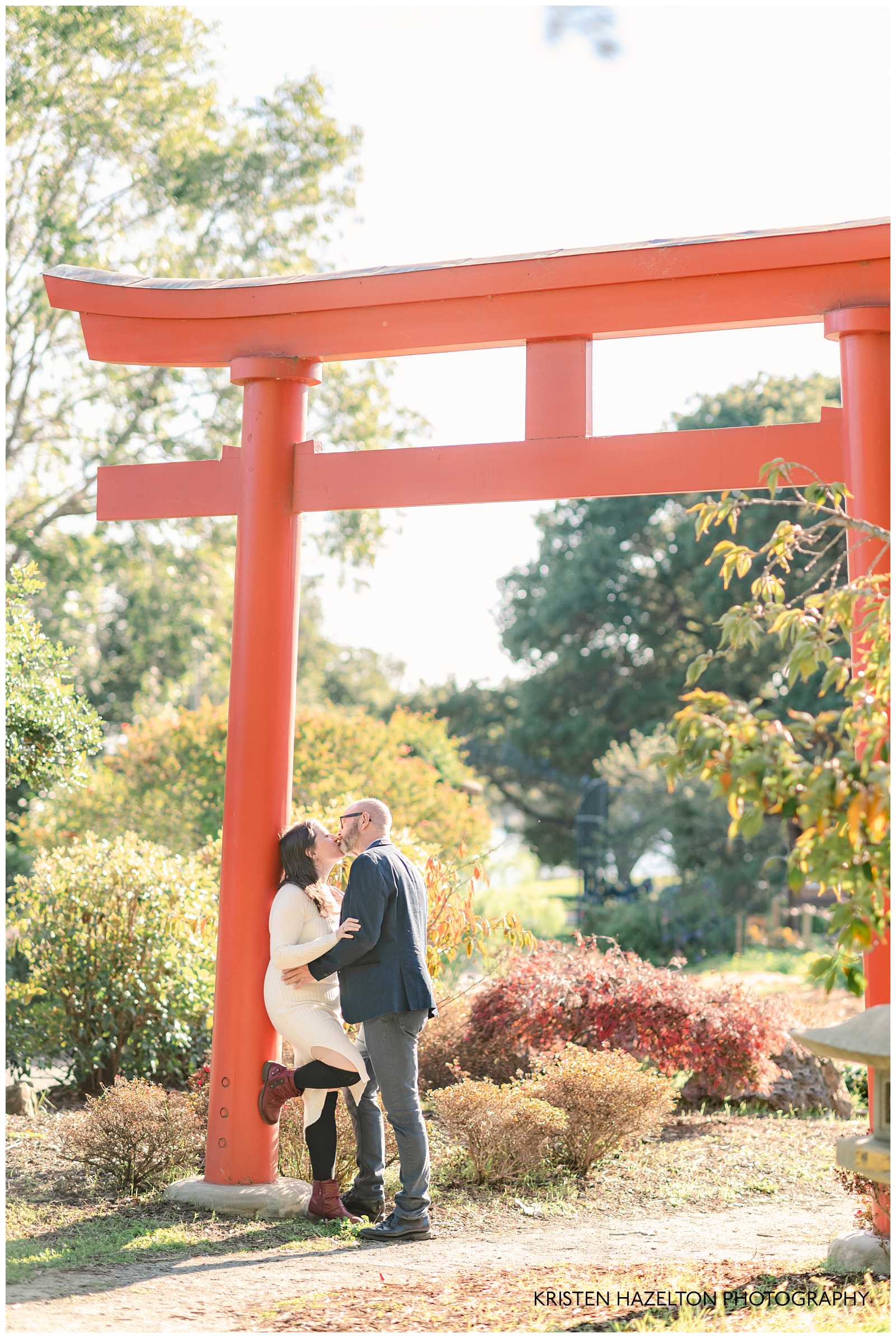 Man and woman kissing at a torii gate  in photos by Bay Area Engagement Photographer Kristen Hazelton