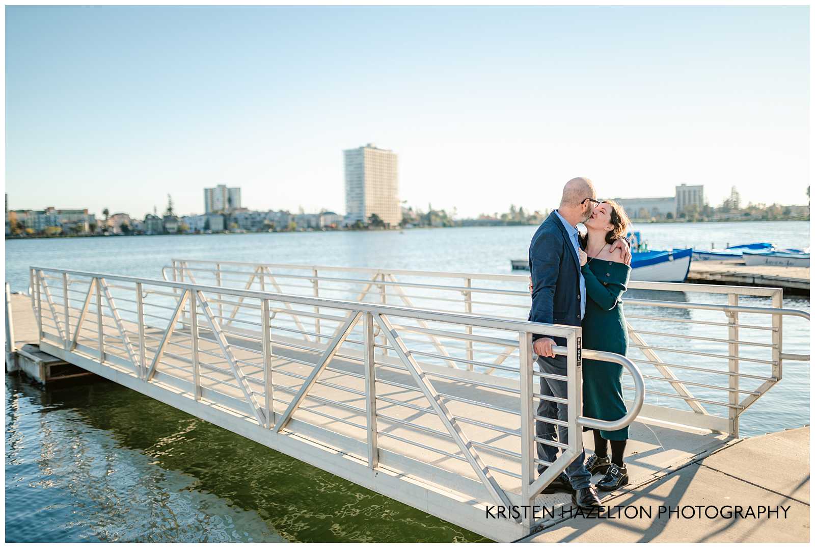 Man and woman kissing on a dock at Lake Merritt in Oakland California