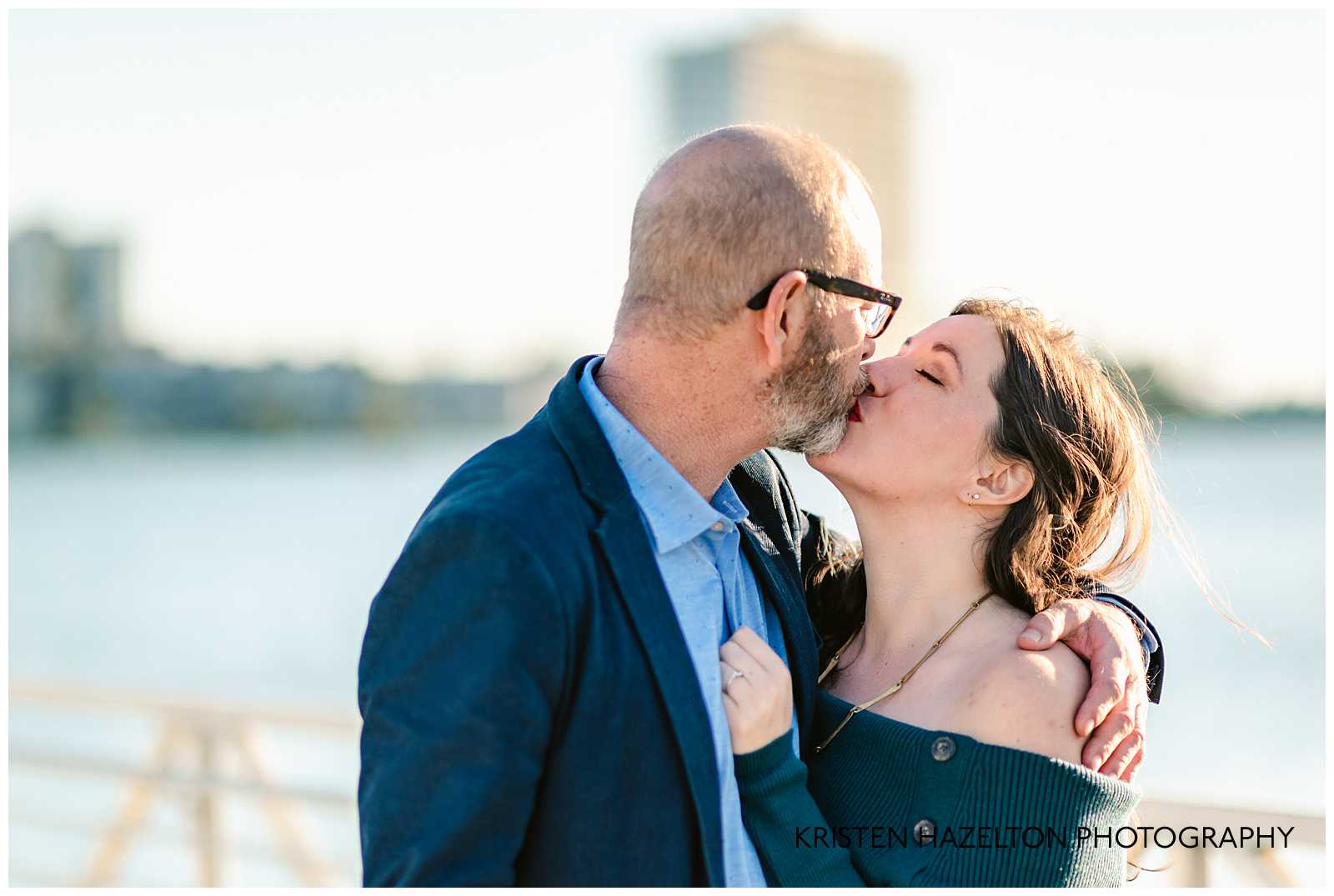 Man and woman kissing at their engagement photoshoot at Lake Merritt in Oakland California