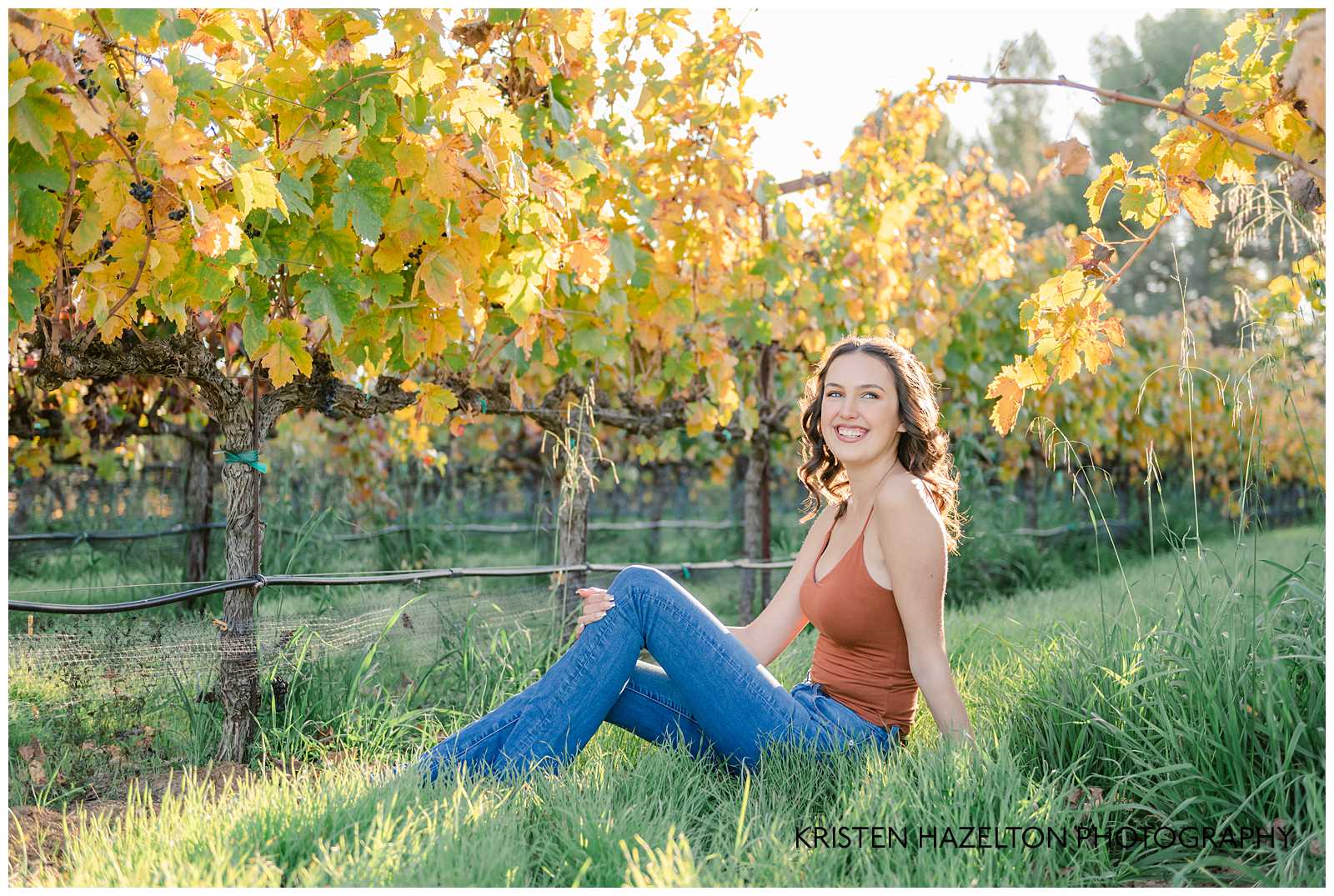 Girl sitting in between rows of grapes by Livermore Senior Photographer Kristen Hazelton