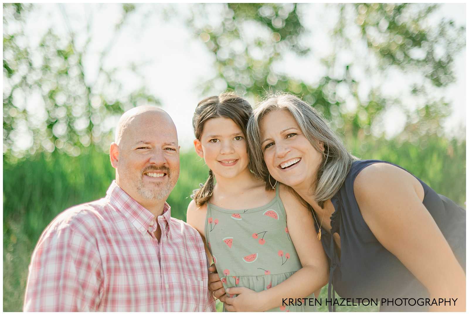 Closeup family photo of three with cattails and trees behind them by Naperville Family Photographer Kristen Hazelton.