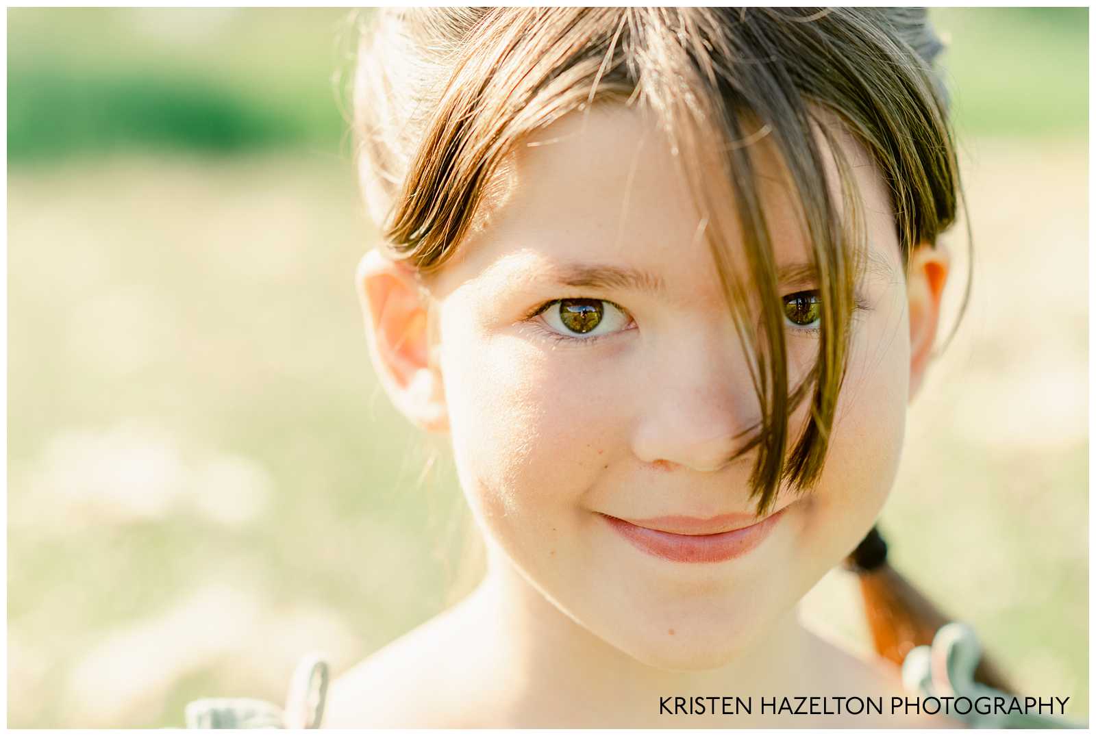 Closeup portrait of a young girl with eyes peeking through her bangs by Naperville Family Photographer Kristen Hazelton.