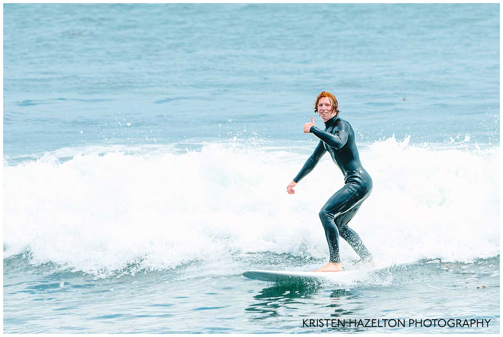 Red haired man surfing and giving thumbs up Surfing photography by Kristen Hazelton. 