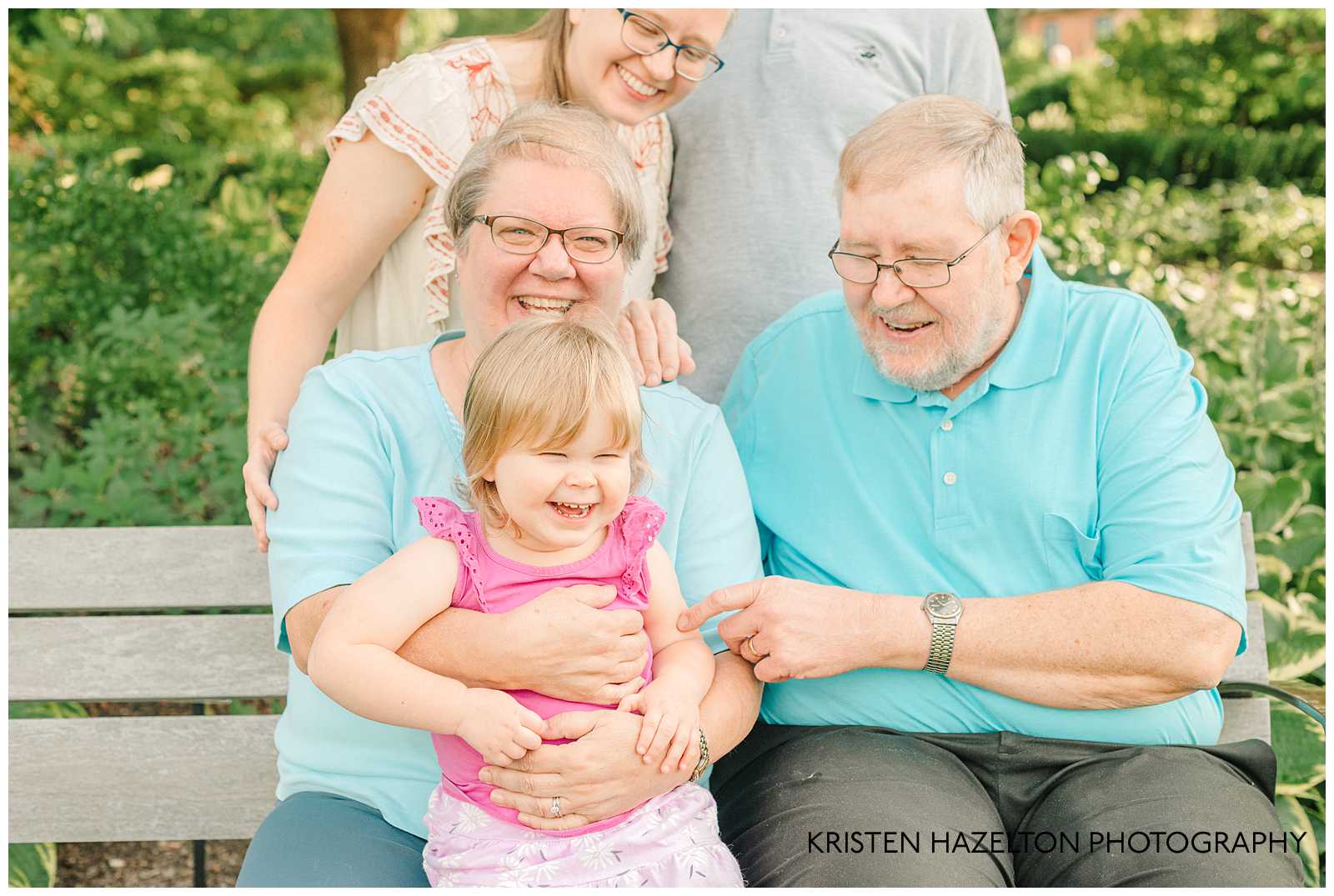 Grandpa tickling toddler granddaughter's arm to make her laugh