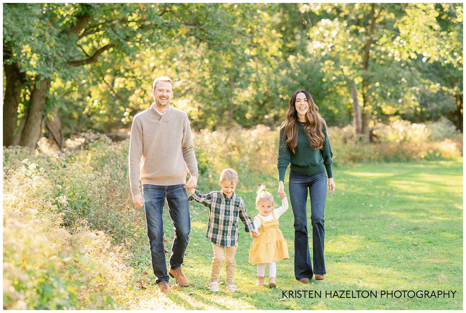 Family of four walking across a grassy field by Elmhurst family photographer Kristen Hazelton