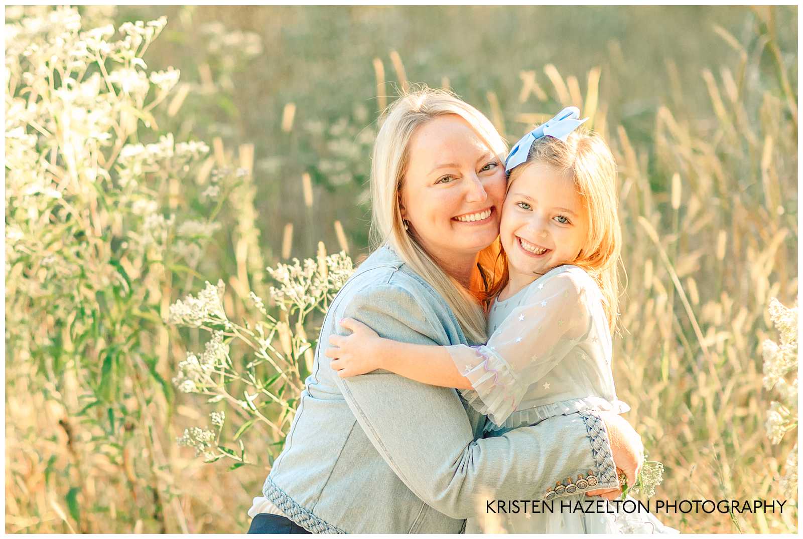 Mom hugging her young daughter cheek to cheek in field of yellow grass. River Forest IL family portraits by Kristen Hazelton