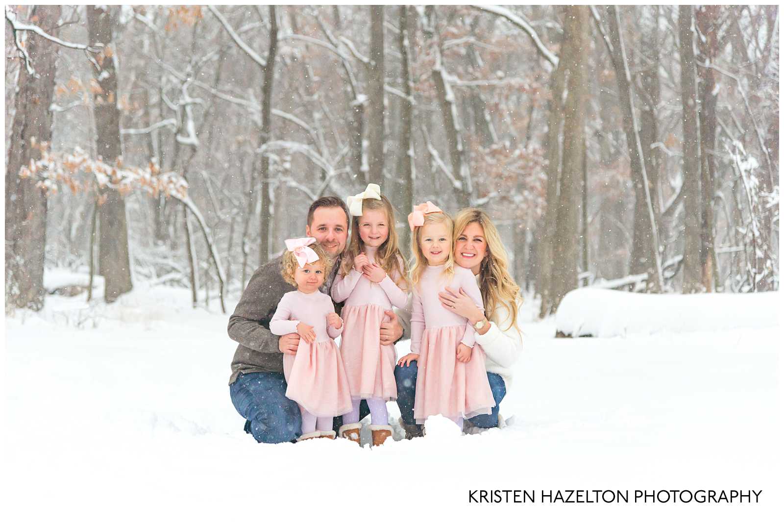 Family with three young daughters in the snowy woods - winter photoshoot ideas by Kristen Hazelton