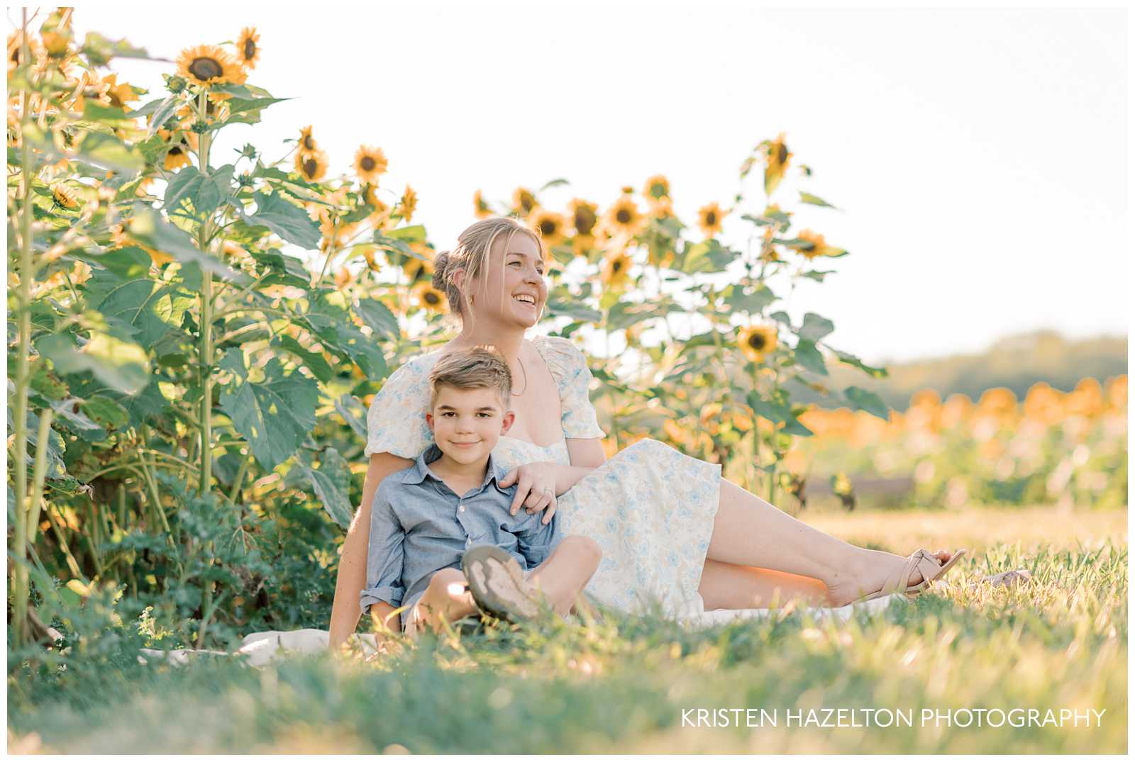 Mother and son seated in a field for a sunflower photoshoot