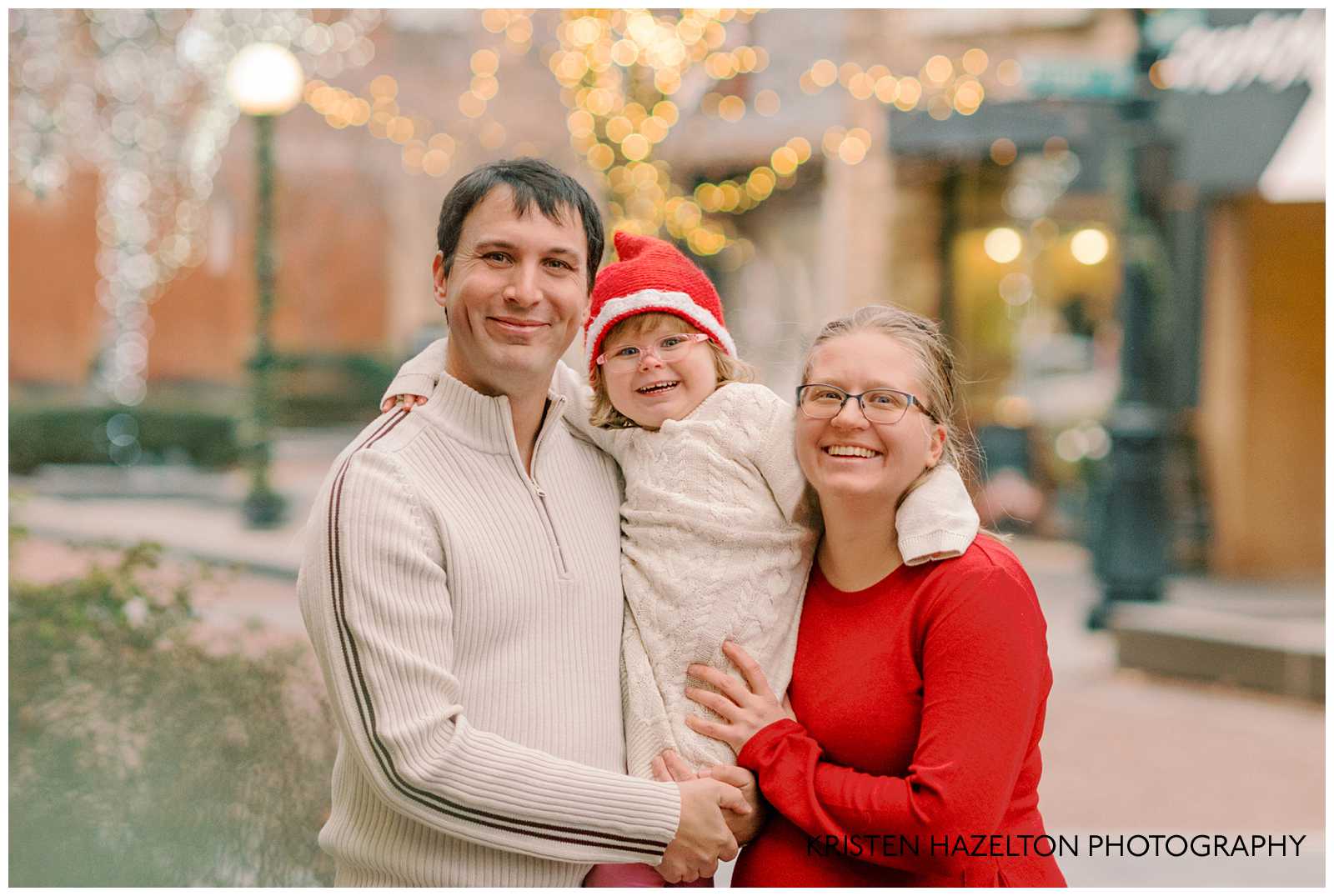 Family of three hugging during their downtown Holiday Lights in Chicago family photoshoot
