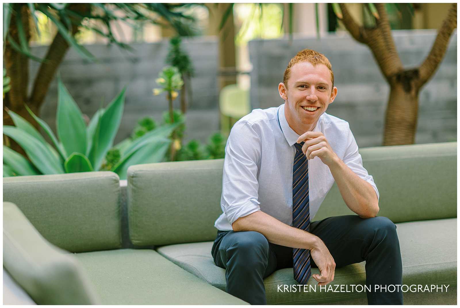 College graduate sitting on a couch outside the Revelle residence hall a for his UC San Diego images for graduation.