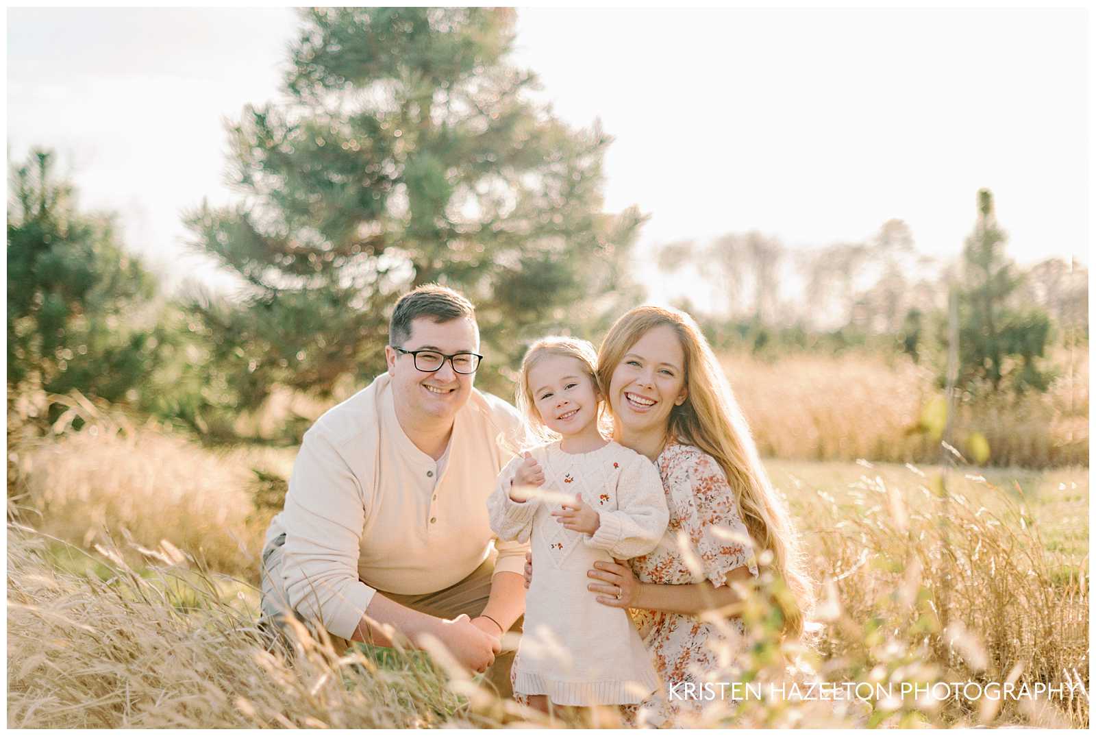 Family of three in white and cream clothes for their Christmas tree farm family photos in Chicago by Oak Park photographer Kristen Hazelton