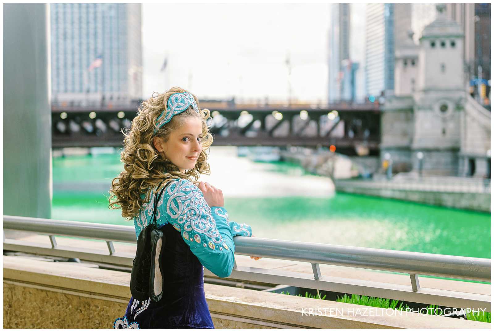 Irish dancer holding her gillies and looking out over the Chicago river, dyed green for St Patricks Day