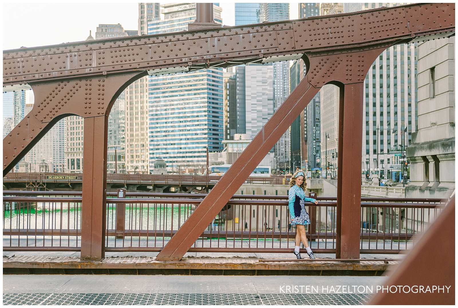 Irish Dancing photography in Chicago; a dancer poses for photos along one of Chicago's drawbridges with the Chicago river dyed green in the background