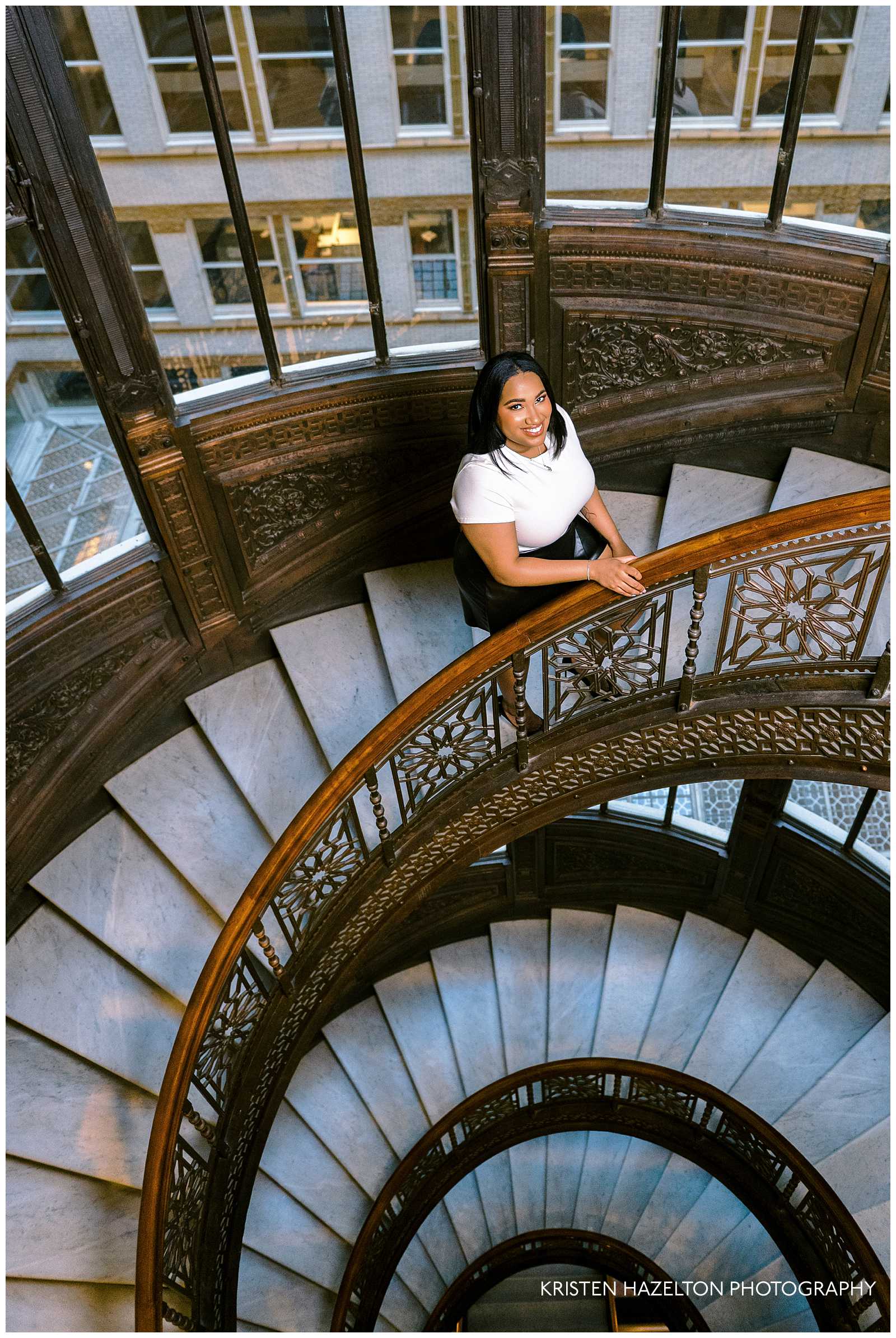 Woman walking up an ornate spiral staircase