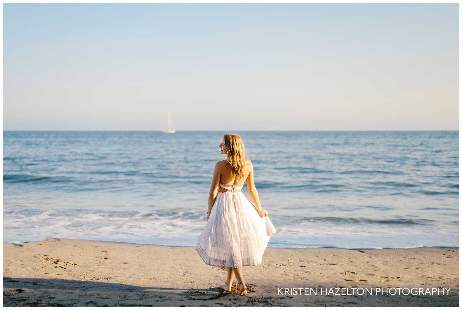 Girl in white dress walking down the beach in Montecito, CA