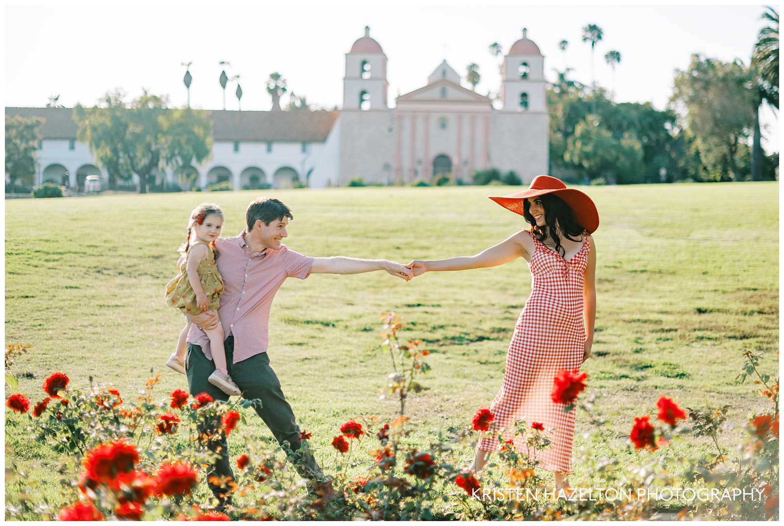 Family holding hands while walking through the roses for their Santa Barbara family photos at the Mission.