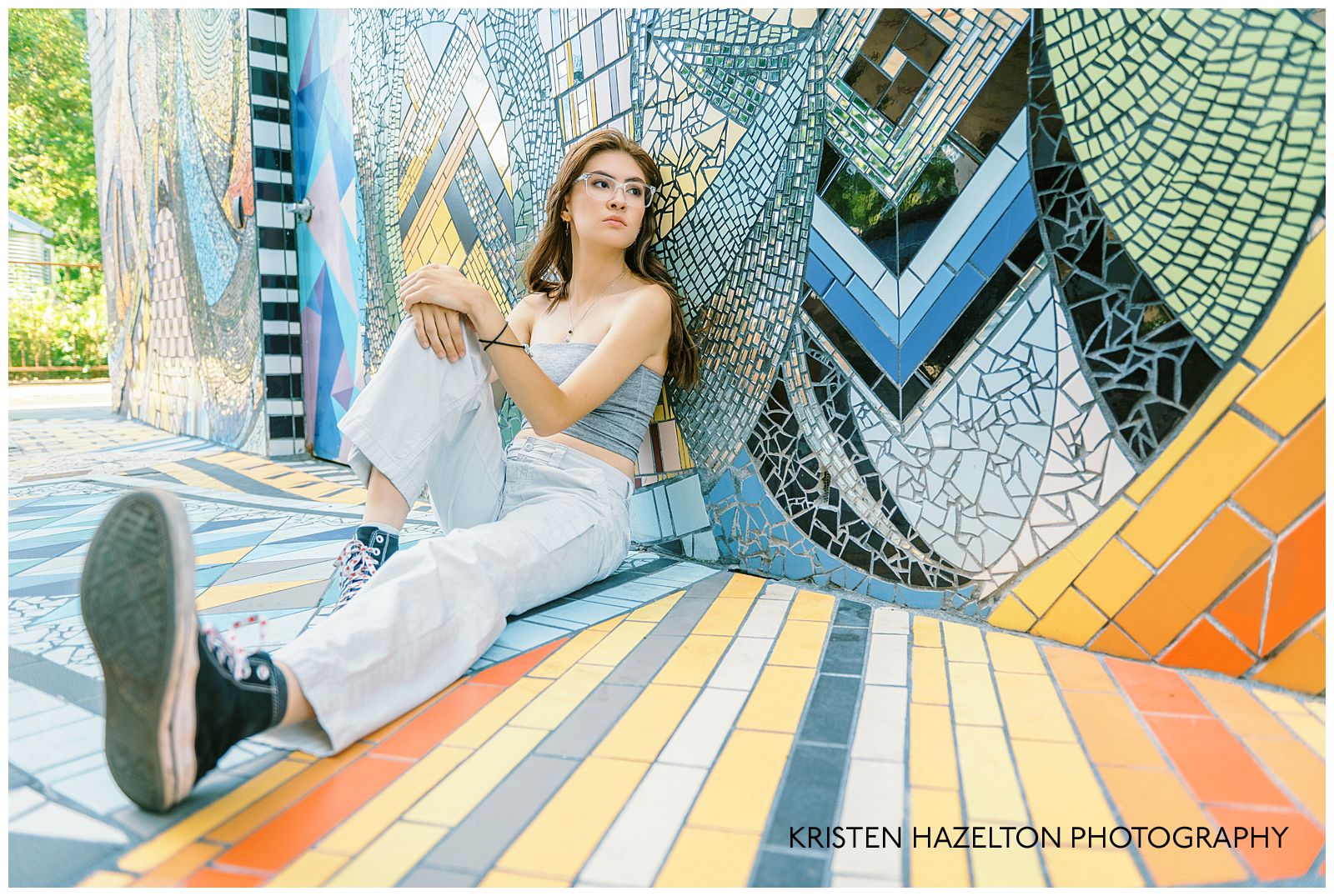 Girl seated against a colorful mosaic for her high school senior photos with Oak Park senior photographer Kristen Hazelton