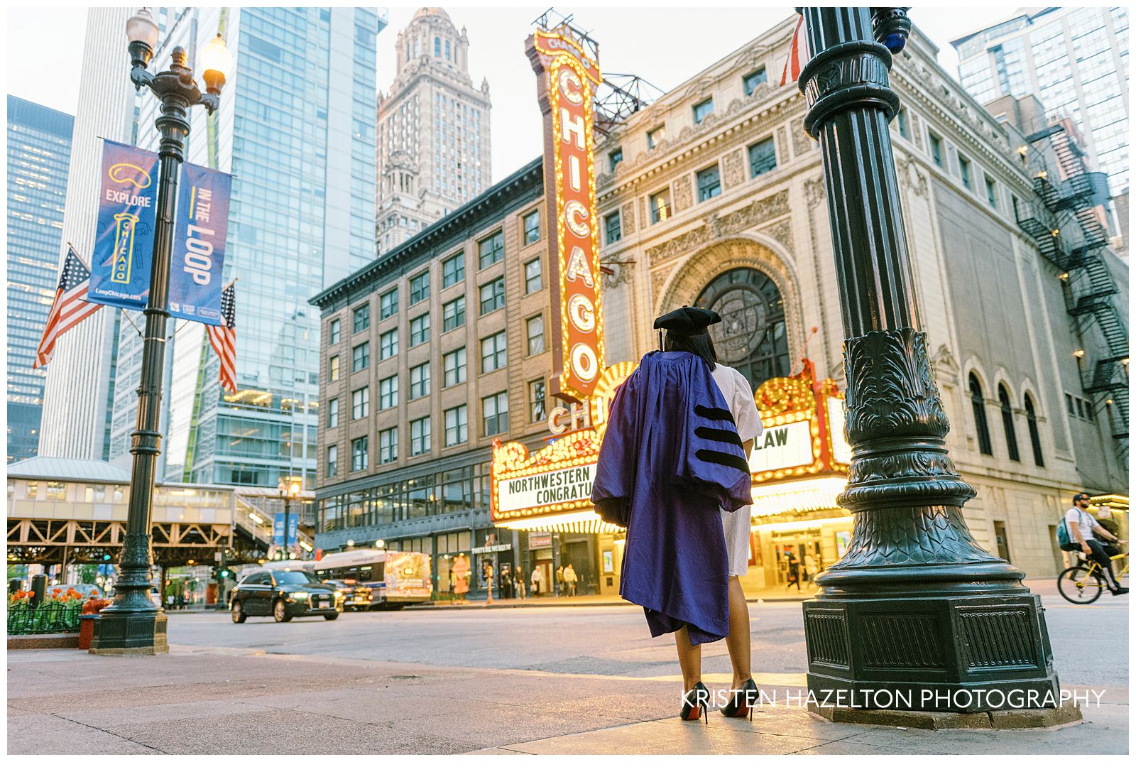 Northwestern graduation portraits in front of the Chicago Theatre; a graduate looks up at the theater sign