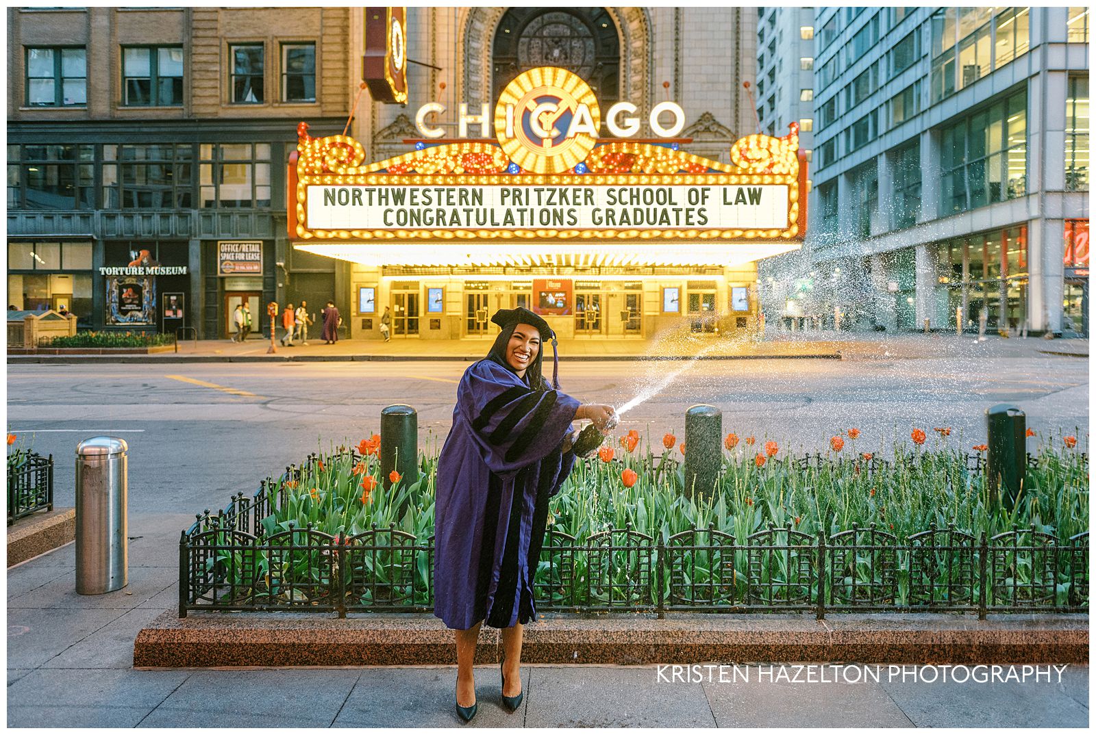 A graduate pops champagne across the street from the theater for her Chicago Theatre photos