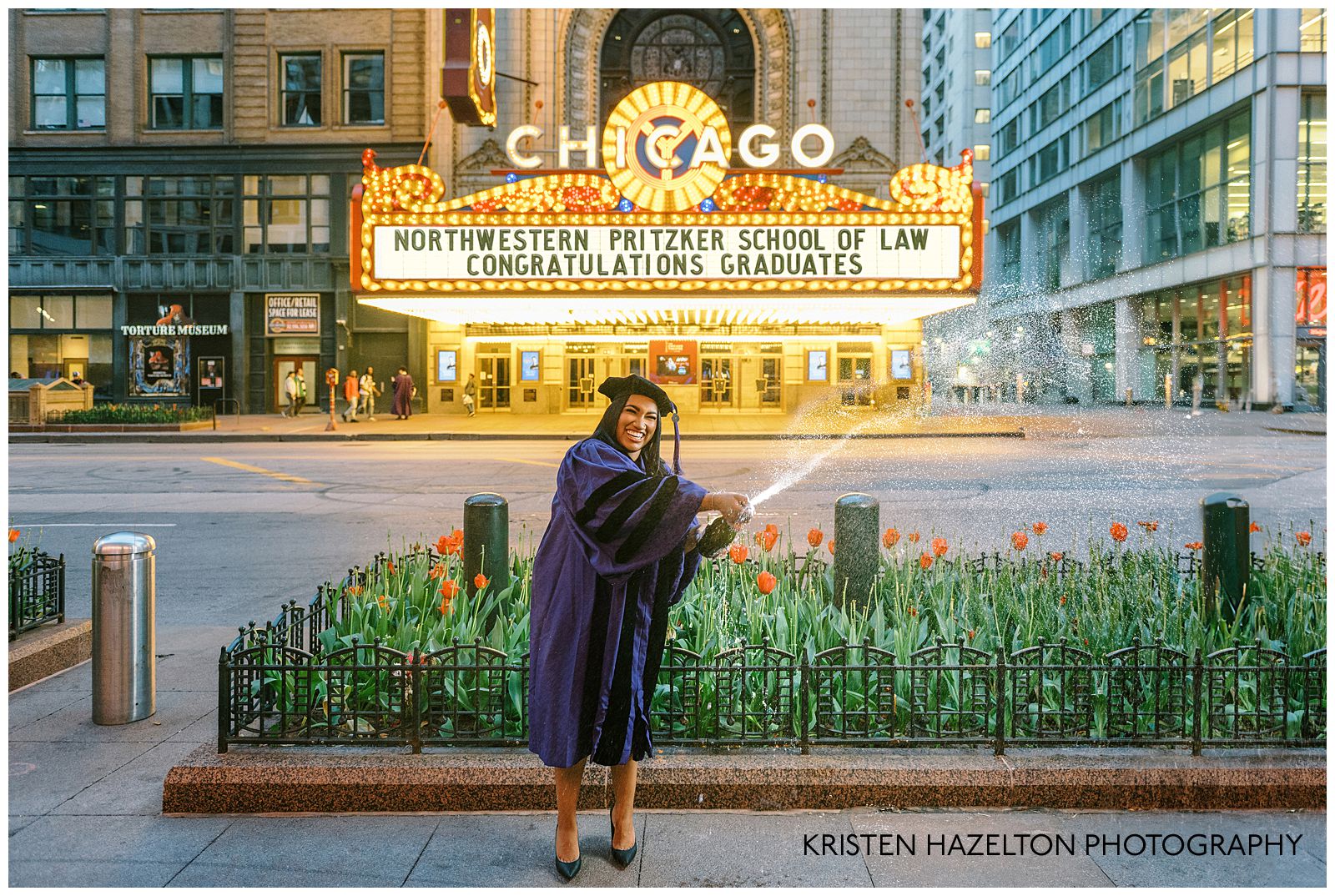 Graduate demonstrating how to pop a champagne bottle for a photoshoot