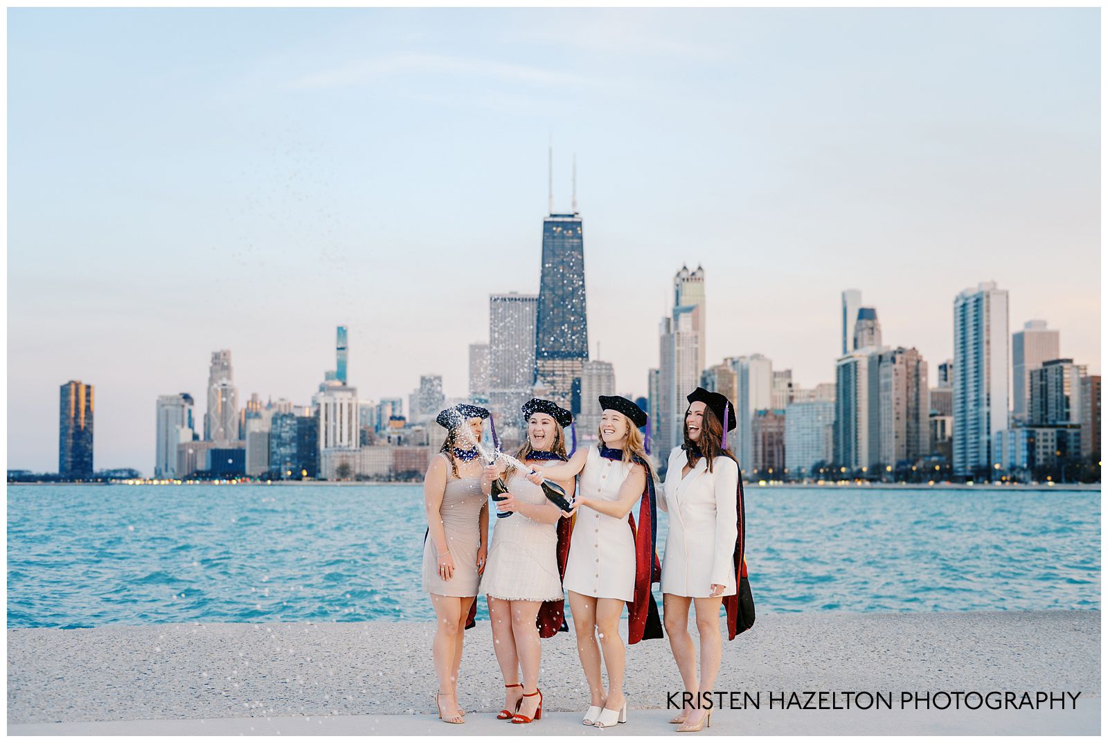 Four graduates popping bottles of champagne during their champagne graduation photos
