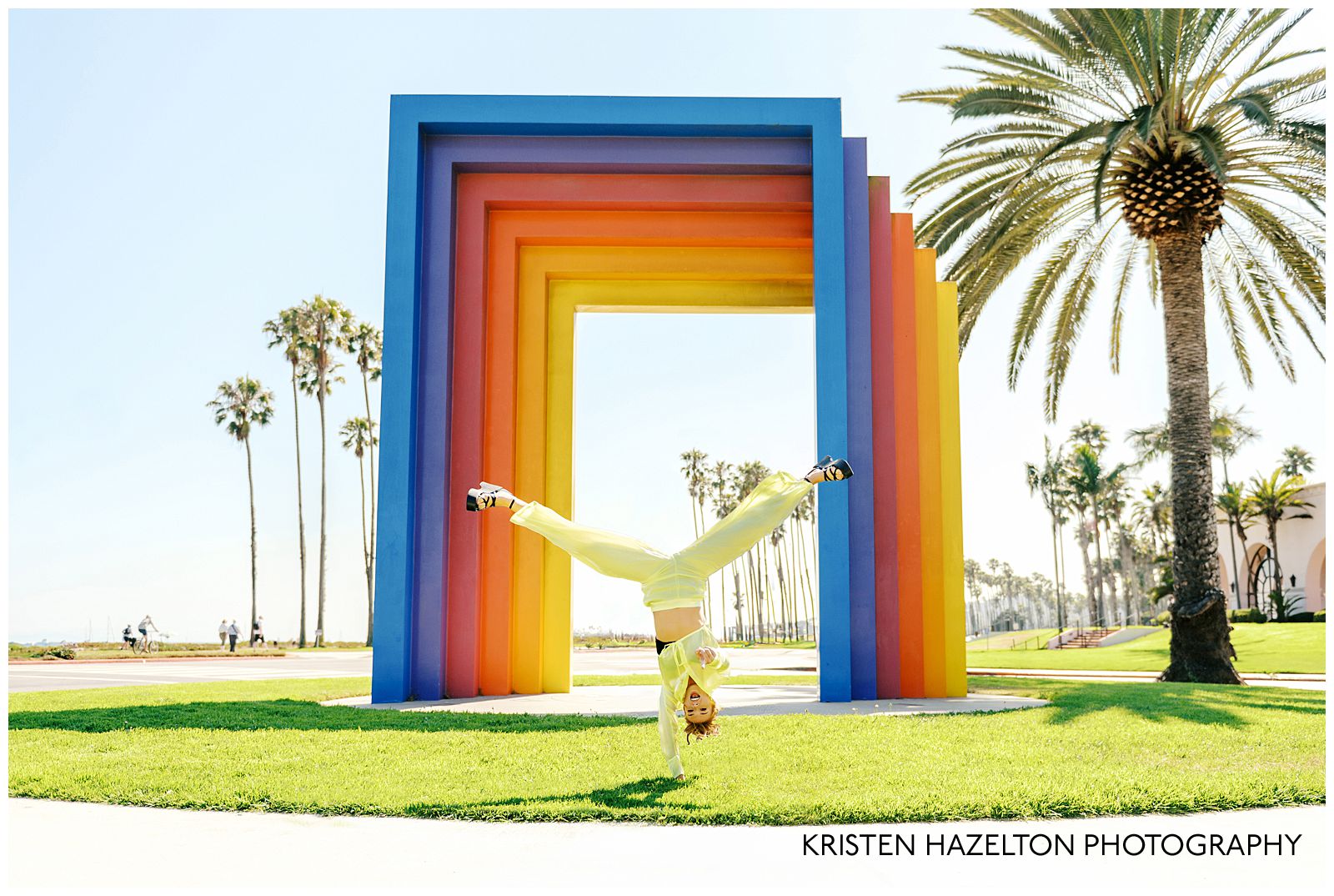 College graduate doing one-handed handstand during her Chromatic Gate photos in Santa Barbara