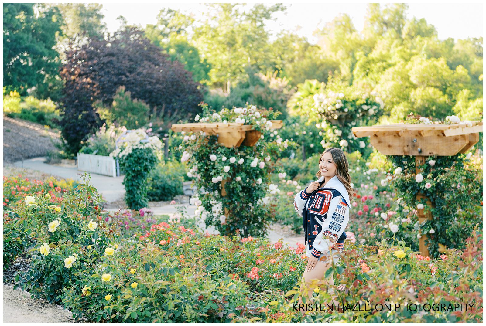 High school senior girl wearing a varsity jacket for her Gardens at Heather Farm photos