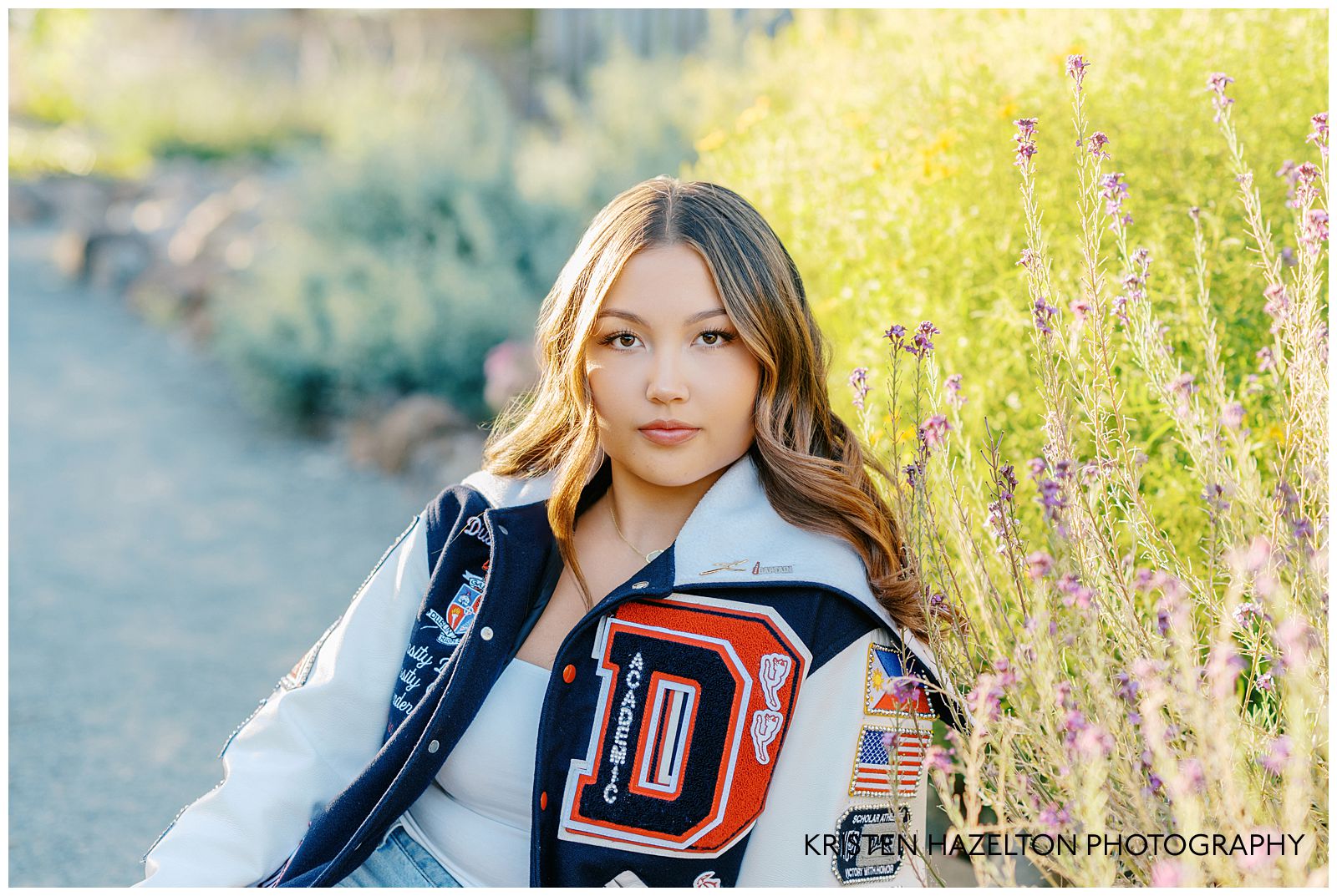 High school senior girl wearing a varsity jacket for her Gardens at Heather Farm photos