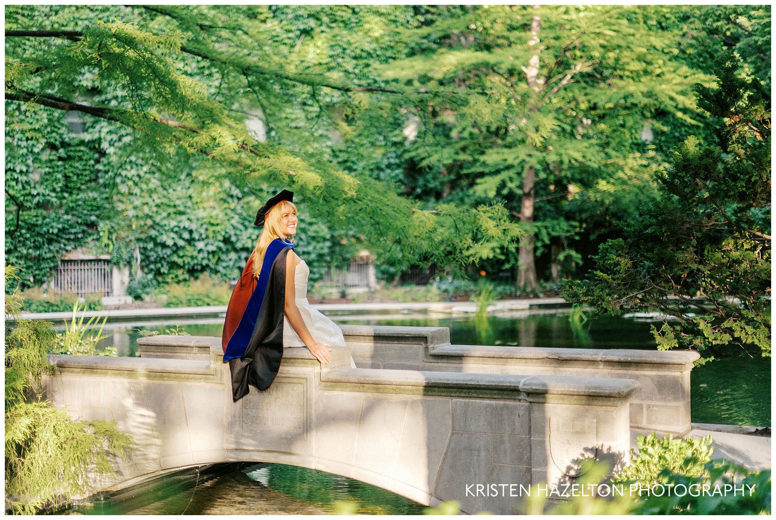 UChicago grad portraits: a PhD graduate sits on the bridge at Botany Pond on the University of Chicago campus.
